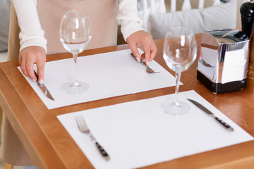 Obraz na płótnie Canvas Waitress putting silverware for guests.