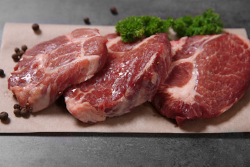 Marbled beef steak and spices on paper napkin on gray background