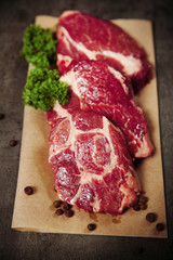 Marbled beef steak and spices on paper napkin on gray background