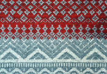 Red knitted background with Christmas patterns - sweater texture