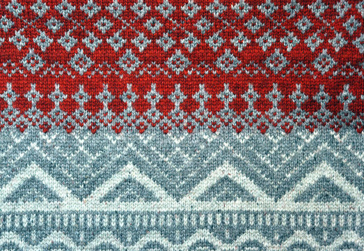 Red knitted background with Christmas patterns - sweater texture