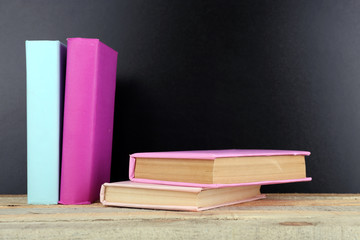 Books on a table on blackboard background