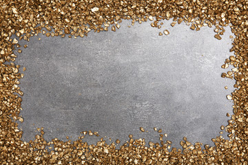 A frame of Gold nugget grains, on cement background