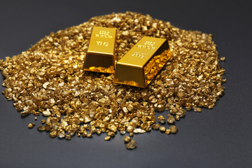Gold bars and nugget grains, on grey background