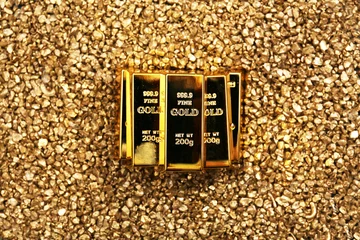 Zelfklevend Fotobehang Gold bars on nugget grains background, close-up, top view © Africa Studio