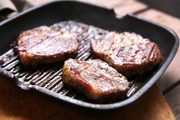 Roasted beef fillet on pan, on wooden background