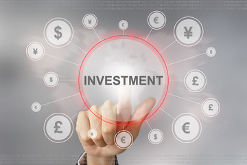 business hand pushing investment button