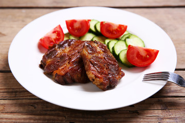 Roasted beef fillet on plate, on wooden background