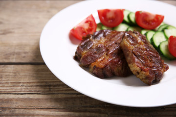 Roasted beef fillet on plate, on wooden background