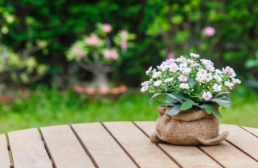 Flower bouquet in a sack on wooden table.