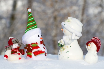 four snowman in the snow looking at each other