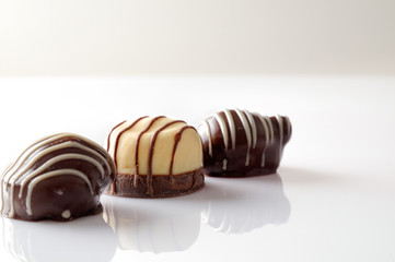Three bonbons on a white table Front view Close up