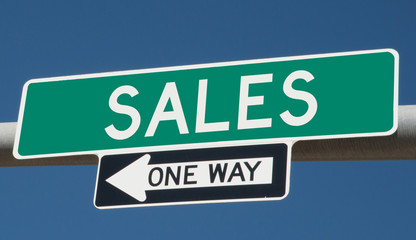 Sales printed on green overhead highway sign with one way arrow 