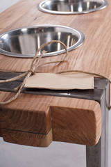 Fototapeta na wymiar Metal Pet dish on wood table / Rustic wood dish stand crafted from scrap