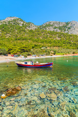 Fototapeta na wymiar Traditional fishing boat in sea bay on secluded beach, Samos island, Greece