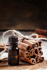 Essential cinnamon oil in a small bottle, ground cinnamon and ci