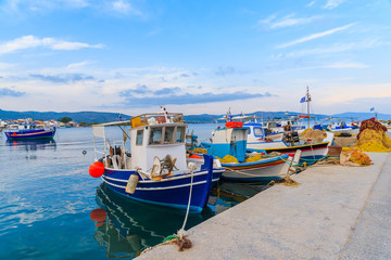 Colourful Greek fishing boats mooring in port at sunset time on Samos island, Greece