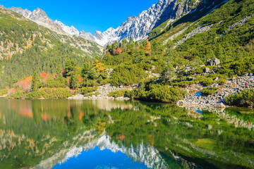 Fototapeta na wymiar Reflection of mountains in Popradske lake in autumn colours of Tatra Mountains, Slovakia