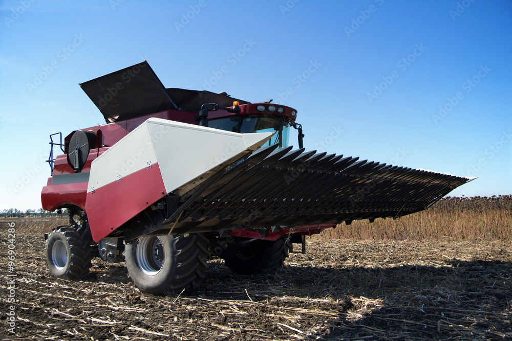 Poster combine harvester working on the field
