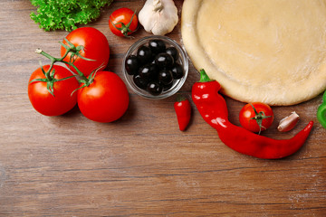 Dough basis and ingredients for pizza, on the table