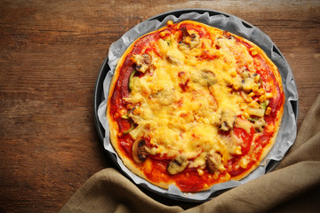 Delicious pizza with vegetables, on wooden table