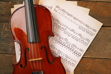 Fototapeta na wymiar Violin and music papers on wooden background