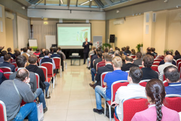 business conference people sitting back and a passage to the screen in the middle