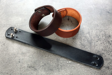 Leather bracelets on grey background