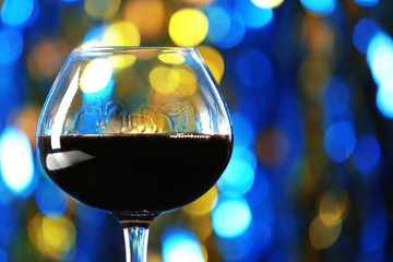 A glass of red wine on blurred lighted background