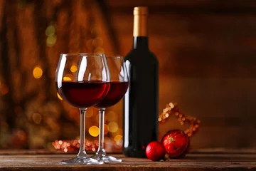 Poster Vin Red wine and Christmas ornaments on wooden table on wooden background