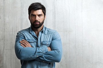 Portrait of a brutal man in a denim shirt