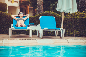 woman lying on a lounger by the pool 
