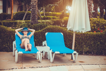 woman lying on a lounger by the pool 
