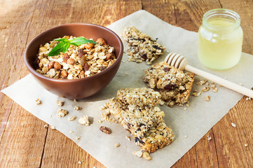 Homemade granola bars with dried fruits and nuts, a jar of honey