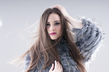 sensual girl in a coat over gray background.