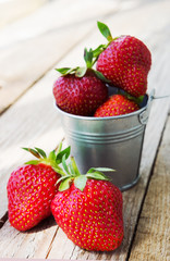 Small bucket filled with fresh red strawberries
