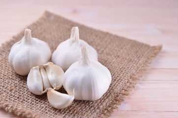 Garlic on sack with wooden background