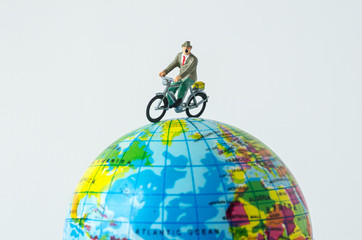 miniature people riding bicycle around the globe © kwanchaift