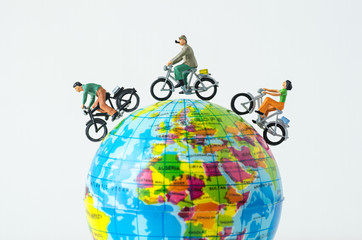 miniature people riding bicycle around the globe © kwanchaift