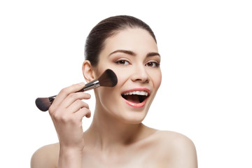 Fototapeta premium Beautiful happy girl applying blush with brush