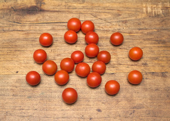 Fototapeta na wymiar Many ripe red tomatoes lies on old vintage wooden surface