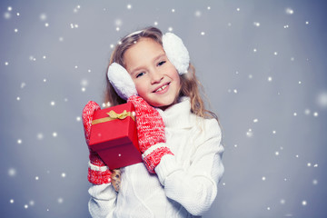 Girl in winter clothes with gift