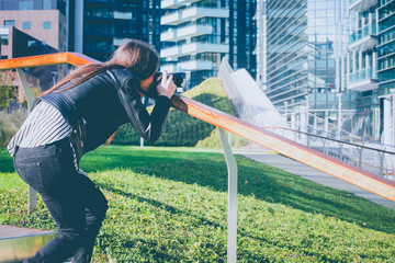 Young beautiful woman taking photo in the city