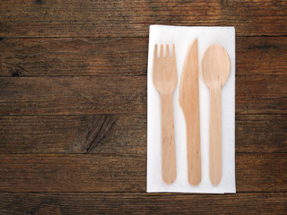 Table setting - ecological wood cutlery on white serviette, napkin