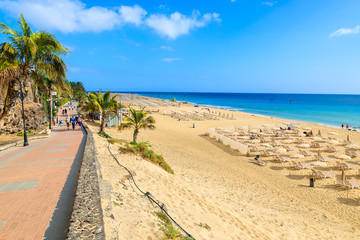 Coastal promenade along sandy beach in Morro Jable town, Fuerteventura, Canary Islands, Spain - obrazy, fototapety, plakaty