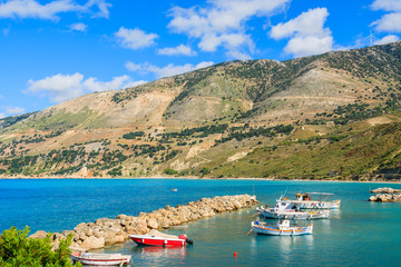 Obraz premium Typical Greek fishing boats in sea bay against mountains in Zola port, Kefalonia island, Greece