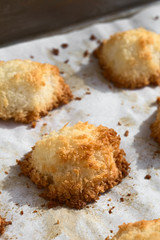 Homemade coconut macaroons (coconut meringue cookies), traditional German Christmas cookies called Kokosmakronen, photographed with natural light (Selective Focus, Focus on the front of the macaroon)