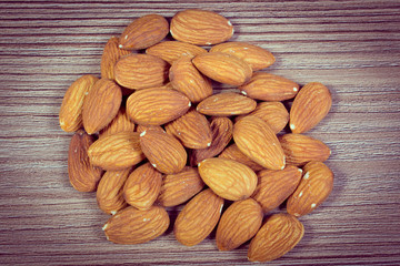 Vintage photo, Heap of almonds on wooden background