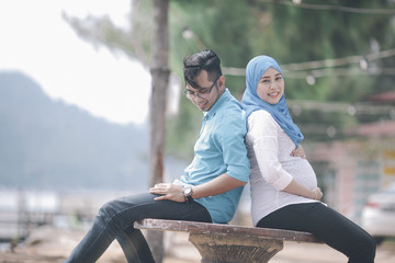 Fototapeta na wymiar Happy and young pregnant couple outdoors