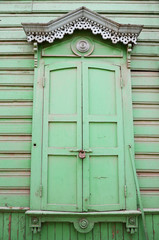 Window with carving architraves and closed shutters